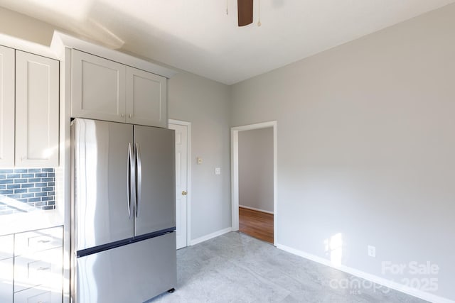 kitchen featuring decorative backsplash, stainless steel fridge, and ceiling fan