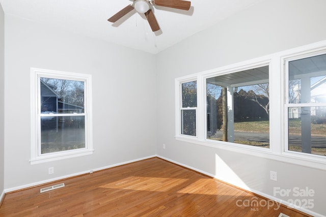 empty room with hardwood / wood-style floors and ceiling fan