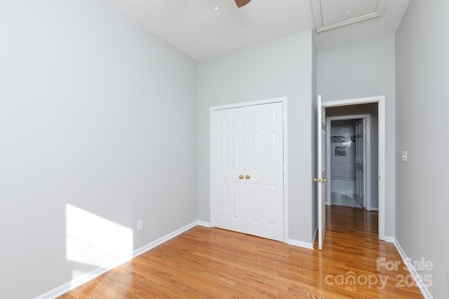 unfurnished bedroom with ceiling fan, a closet, and wood-type flooring