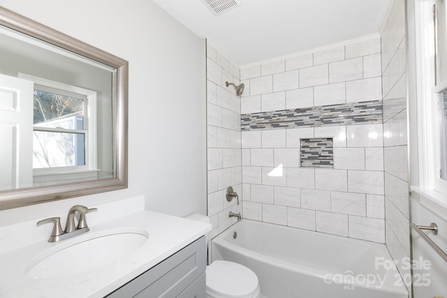 full bathroom featuring toilet, vanity, and tiled shower / bath