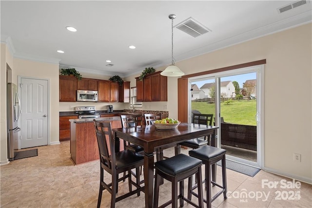 dining area with ornamental molding and light tile patterned flooring