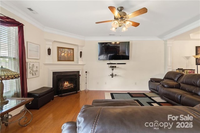 living room with hardwood / wood-style floors, ceiling fan, and ornamental molding