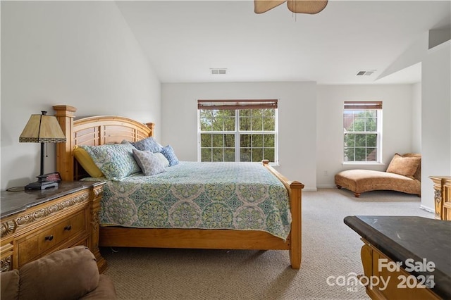 carpeted bedroom featuring ceiling fan, vaulted ceiling, and multiple windows