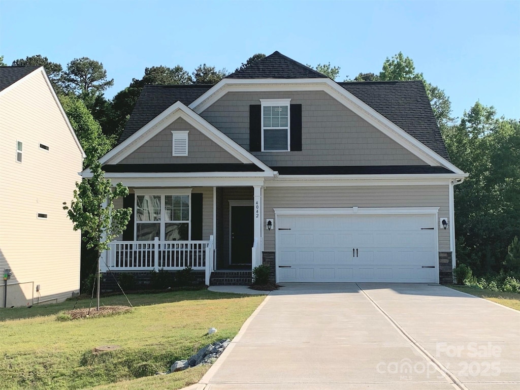 craftsman-style home featuring a front yard, a garage, and a porch