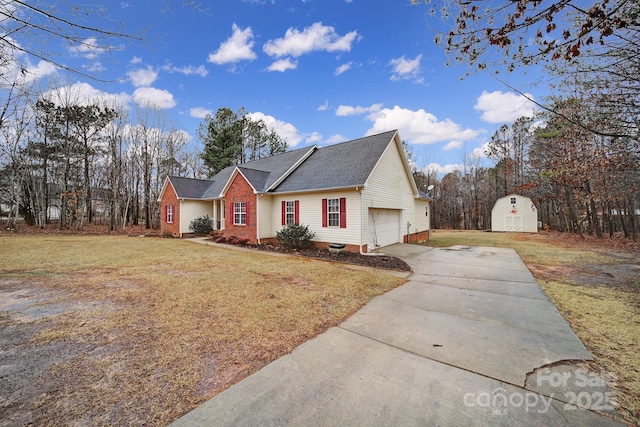 view of front of home with a garage, a front lawn, and a storage shed