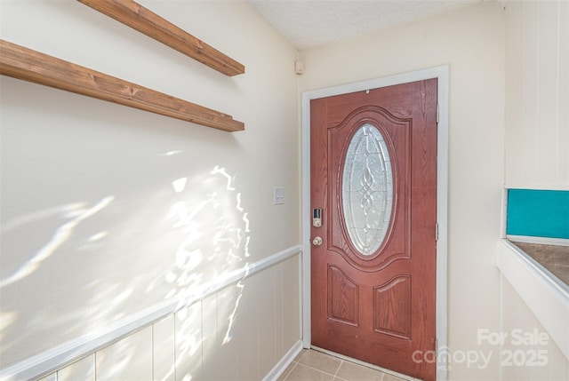 tiled foyer featuring a textured ceiling