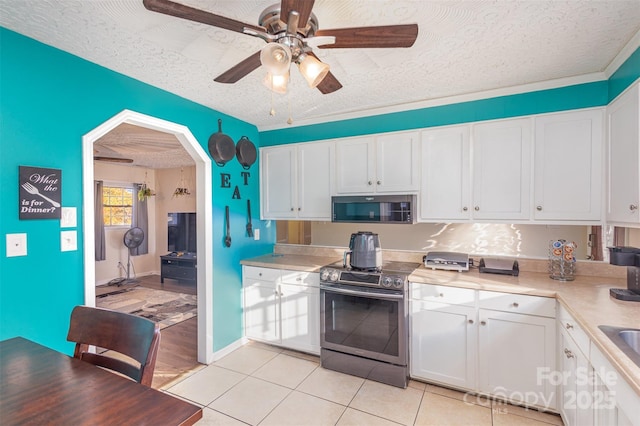 kitchen featuring ceiling fan, stainless steel appliances, white cabinets, a textured ceiling, and light tile patterned floors