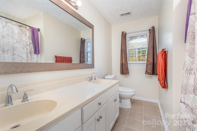 bathroom featuring tile patterned flooring, vanity, toilet, and a textured ceiling