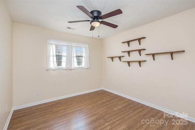 spare room featuring ceiling fan, wood-type flooring, and a textured ceiling