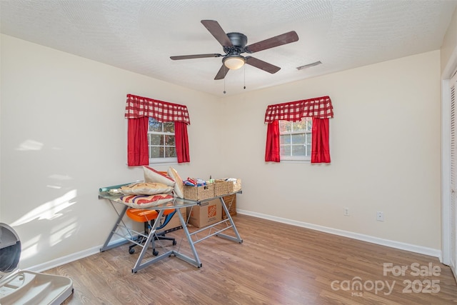 office area with hardwood / wood-style flooring, ceiling fan, and a textured ceiling