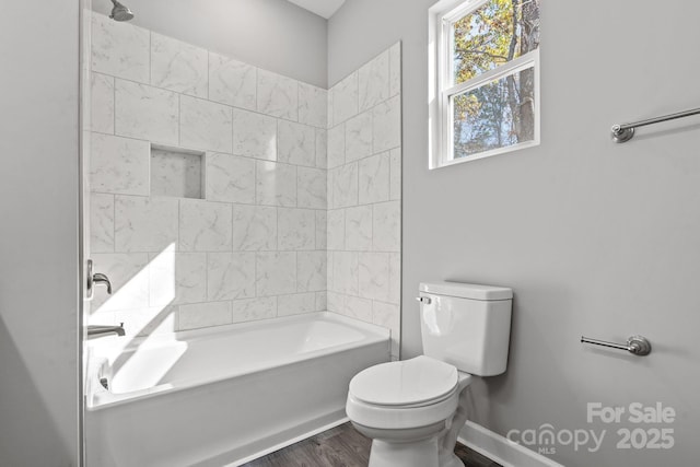 bathroom featuring hardwood / wood-style floors, toilet, and tiled shower / bath