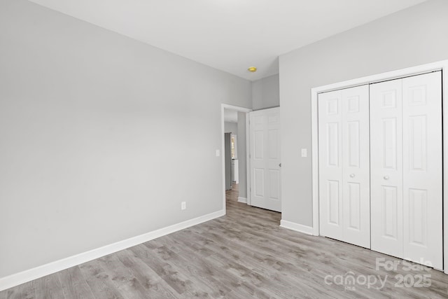 unfurnished bedroom with light hardwood / wood-style floors and a closet