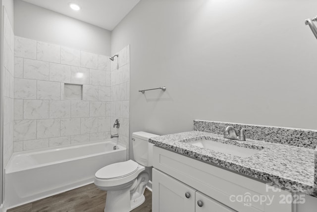 full bathroom featuring wood-type flooring, vanity, toilet, and tiled shower / bath