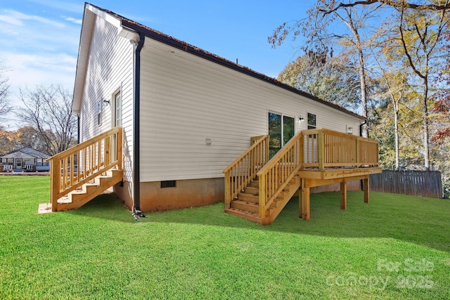 rear view of property with a yard and a wooden deck