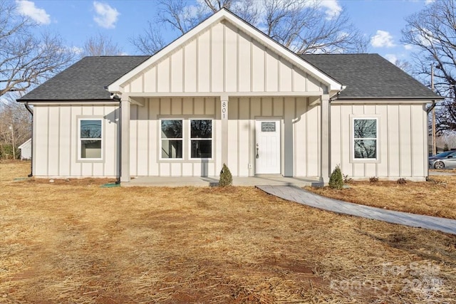 modern farmhouse style home with a porch and a front lawn