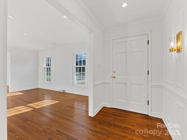 foyer with dark wood-type flooring and ornamental molding