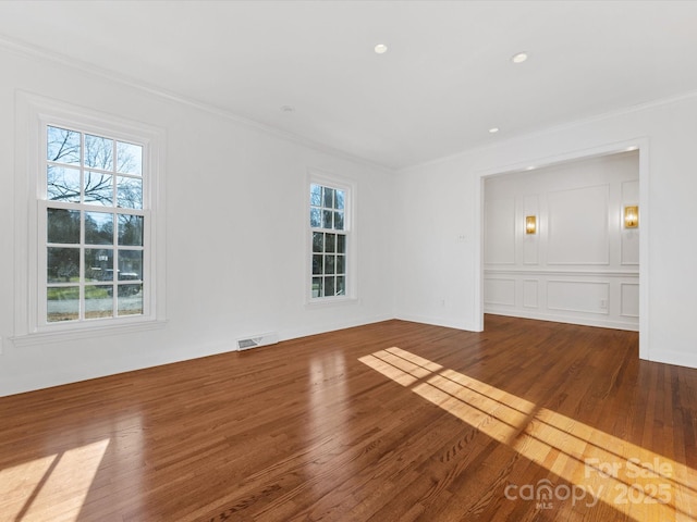 empty room featuring hardwood / wood-style floors and ornamental molding