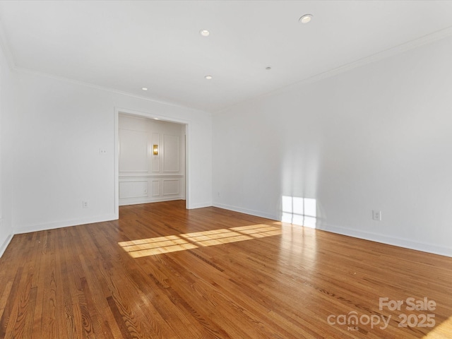 empty room featuring crown molding and light hardwood / wood-style floors