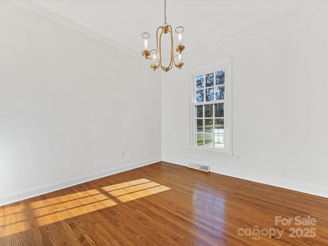 unfurnished room with a notable chandelier, wood-type flooring, and crown molding