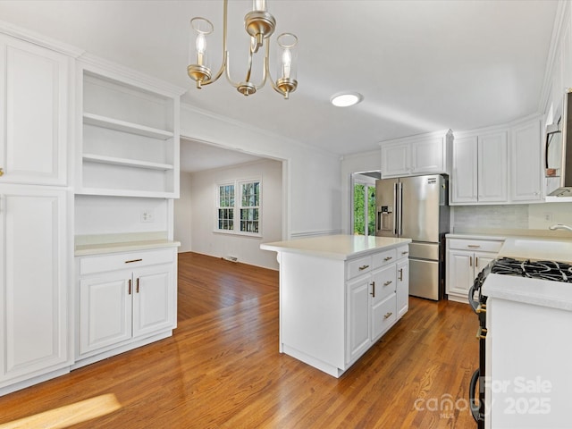 kitchen featuring hanging light fixtures, a kitchen island, light hardwood / wood-style floors, white cabinetry, and stainless steel appliances