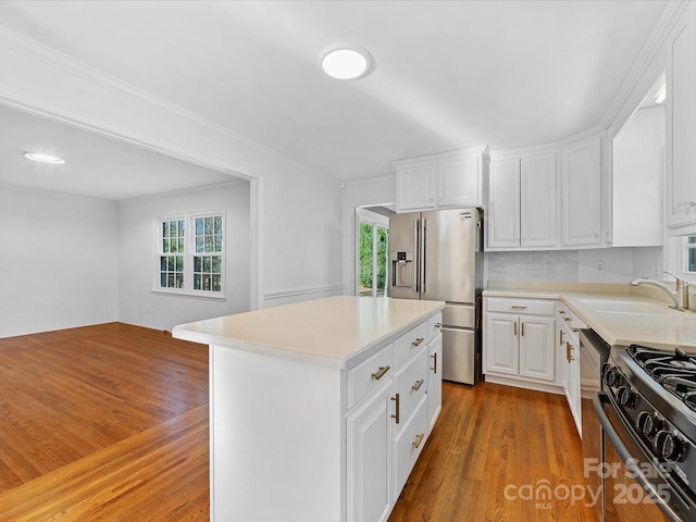 kitchen featuring high end fridge, a kitchen island, white cabinetry, and sink