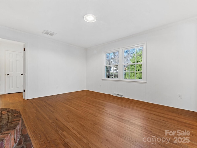 empty room with hardwood / wood-style floors and ornamental molding