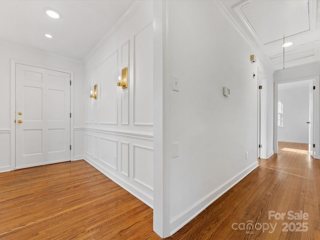 hallway with wood-type flooring and ornamental molding