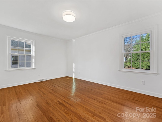 spare room with hardwood / wood-style flooring and crown molding