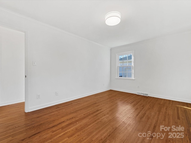 spare room with wood-type flooring and ornamental molding