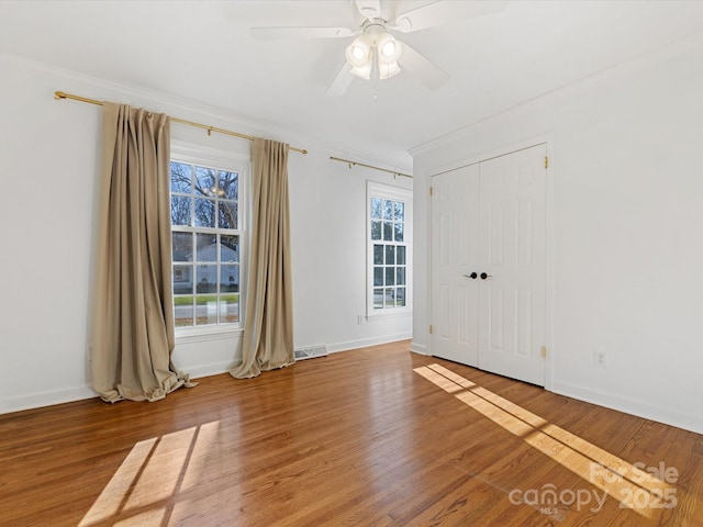 unfurnished room featuring a wealth of natural light, crown molding, ceiling fan, and hardwood / wood-style flooring