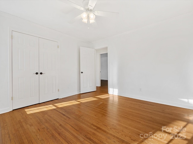 unfurnished bedroom with a closet, hardwood / wood-style flooring, and ceiling fan