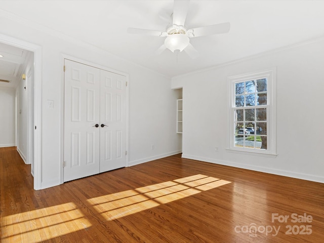 unfurnished bedroom with hardwood / wood-style floors, a closet, ceiling fan, and ornamental molding