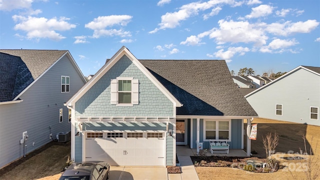 view of front of house with covered porch, central AC unit, and a garage