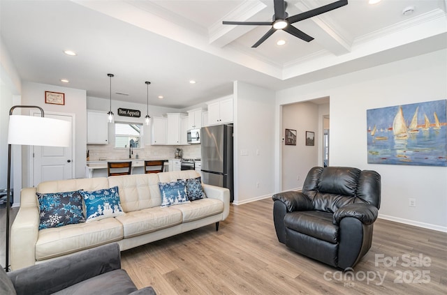 living room featuring beamed ceiling, ceiling fan, light hardwood / wood-style floors, and crown molding