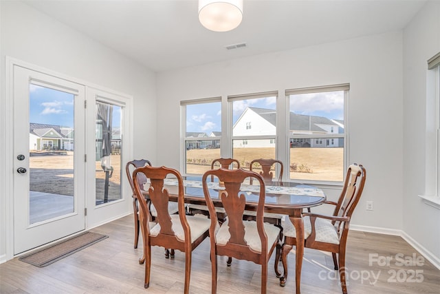 dining space featuring a healthy amount of sunlight and light hardwood / wood-style flooring