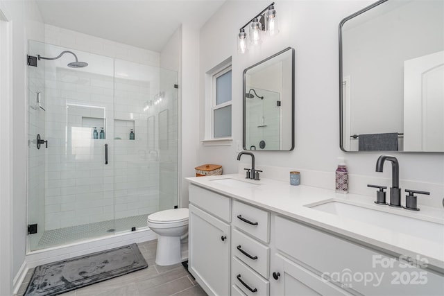 bathroom featuring vanity, toilet, and a shower with shower door