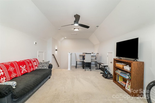 carpeted living room with ceiling fan and vaulted ceiling