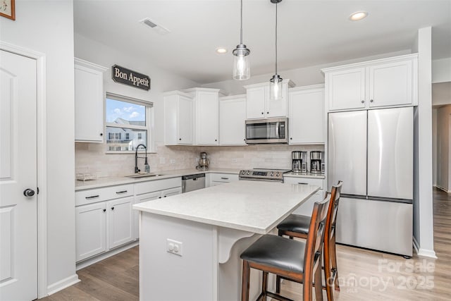 194 Tillery Ln, Mount Gilead, NC 27306 - kitchen with appliances with stainless steel finishes, decorative backsplash, a kitchen island, white cabinetry, and recessed lighting