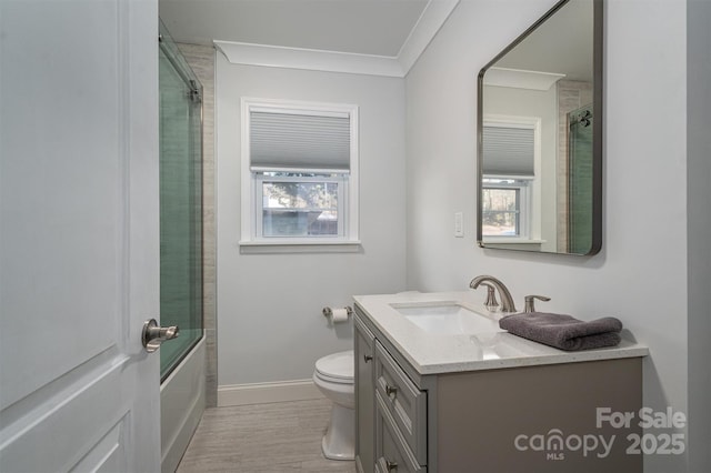 full bathroom featuring vanity, crown molding, bath / shower combo with glass door, and toilet