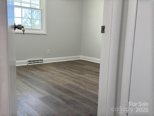 spare room with dark wood-type flooring