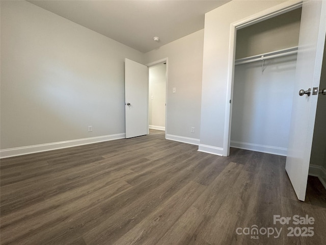 unfurnished bedroom featuring dark hardwood / wood-style flooring and a closet