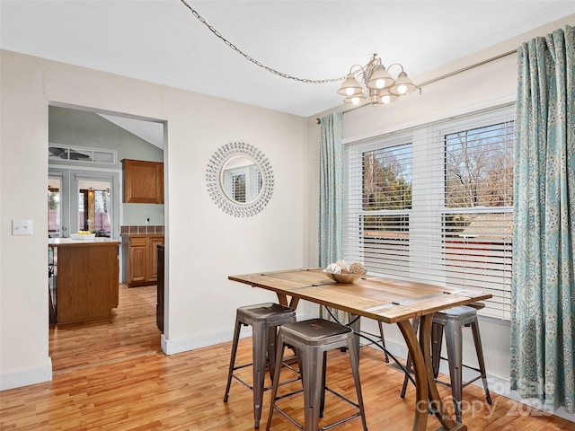 dining room featuring a wealth of natural light, light hardwood / wood-style floors, and an inviting chandelier