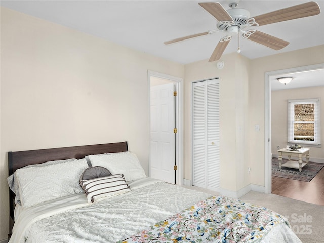 carpeted bedroom featuring ceiling fan and a closet