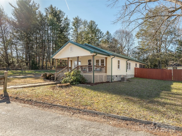 view of front of home with covered porch, central air condition unit, and a front lawn