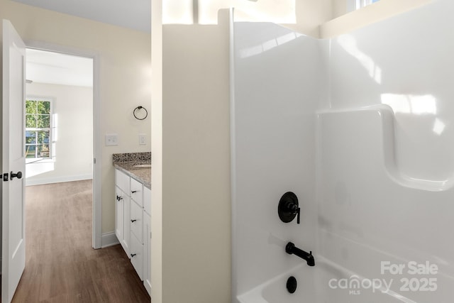 full bathroom featuring vanity, baseboards, wood finished floors, and shower / bathtub combination