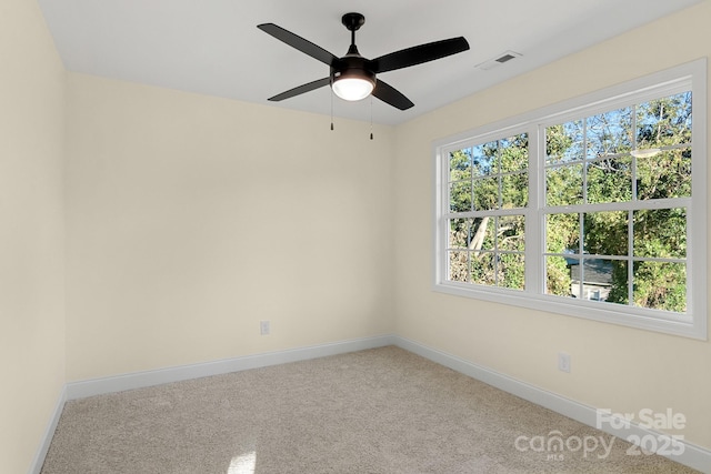 unfurnished room featuring carpet, visible vents, ceiling fan, and baseboards