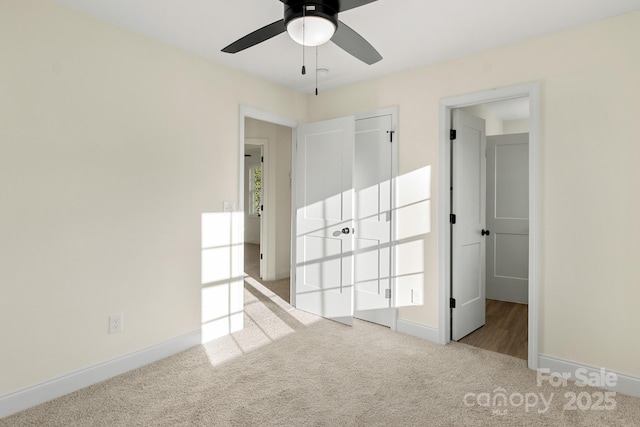 unfurnished bedroom featuring carpet, baseboards, and ceiling fan