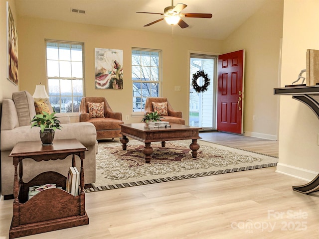 living room featuring ceiling fan, light wood-type flooring, vaulted ceiling, and a wealth of natural light