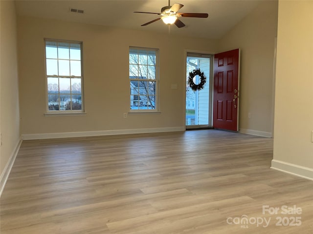 foyer with ceiling fan, a wealth of natural light, and light hardwood / wood-style floors