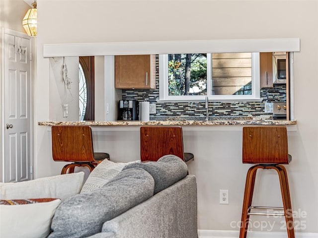 kitchen featuring a healthy amount of sunlight, sink, and backsplash